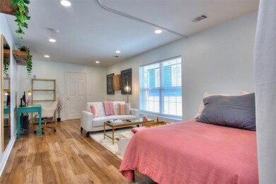 Bedroom featuring light wood-style floors, recessed lighting, and an office area