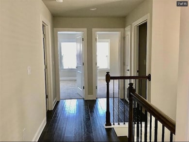 Corridor with an upstairs landing and dark wood-type flooring