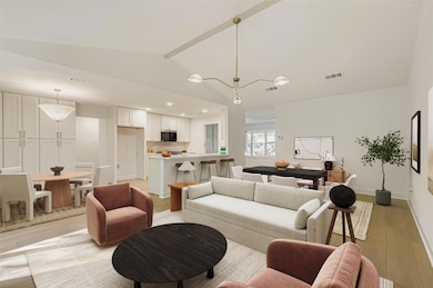 Living area with light wood-style floors, vaulted ceiling, and recessed lighting