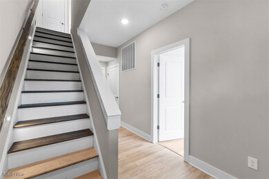 Staircase featuring wood finished floors and recessed lighting