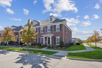 Colonial inspired home with brick siding and a front yard