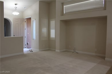 Foyer entrance with light carpet and arched walkwa