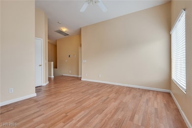 Empty room with light wood-style floors and ceiling fan