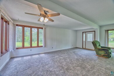 Unfurnished office featuring a textured ceiling, ceiling fan, carpet, and baseboards