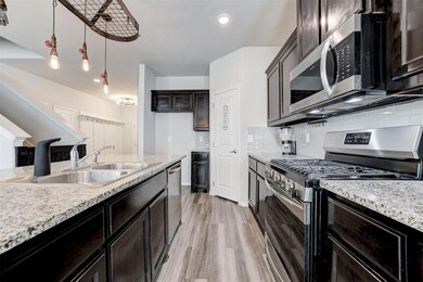 Kitchen with decorative backsplash, light hardwood