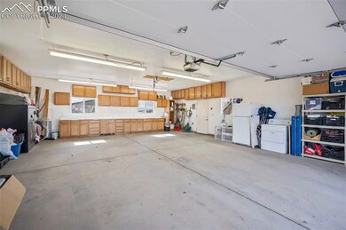 Garage featuring white fridge and washer / clothes