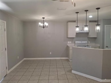 Kitchen featuring white electric stove, light countertops, decorative light fixtures, light tile patterned floors, and recessed lighting