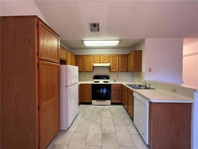 Kitchen featuring brown cabinets, a sink, under c