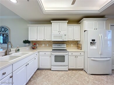 Kitchen featuring sink, backsplash, white cabinets