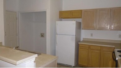Kitchen featuring white appliances, light counter