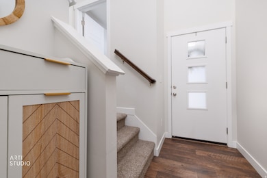Entrance foyer with stairway and dark wood-style floors