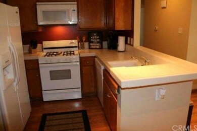 Kitchen with tile counters, built-in microwave, ga
