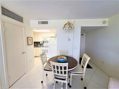 Dining room featuring light tile patterned flooring and a textured ceiling