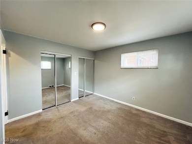 Unfurnished bedroom with multiple closets and carpet