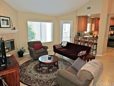 Living room open to kitchen and bar seating.