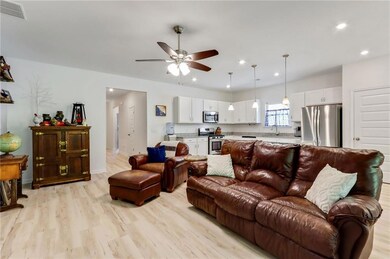 Living room with a ceiling fan, recessed lighting, and light wood-style flooring