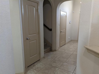 Hallway showing garage entrance, stairs, and closet