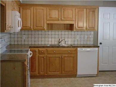 Eat in kitchen with custom wood cabinets, stone co