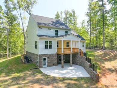 Back of house with a lawn and a patio