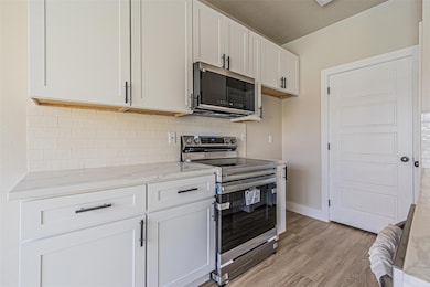 Kitchen featuring light stone countertops, light w