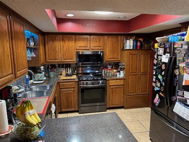 Kitchen with brown cabinets, appliances with stain