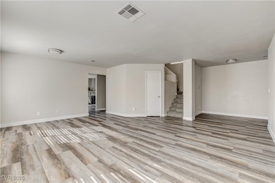 Unfurnished room featuring light wood-type flooring and stairway