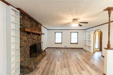 Living room with a stone fireplace, built-in bookcases and new LVP flooring