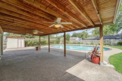 A 26'x14' covered patio with concrete floors and a cool breeze from a trio of ceiling fans overlooks the impressively sized and beautifully landscaped backyard complete with an included storage shed.