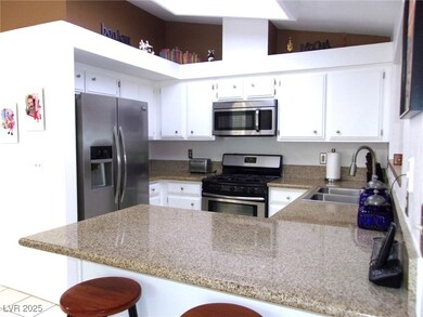 Kitchen with vaulted ceiling, a sink, a peninsula,