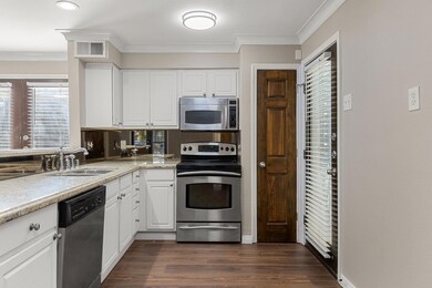 Kitchen with ornamental molding, dark wood-type fl