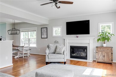 Living room with crown molding, wood floors, a cei