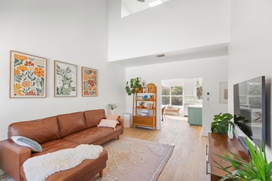 Living room with a high ceiling, visible vents, a
