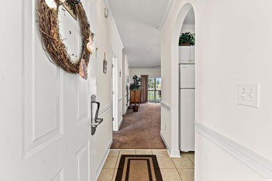 Hall featuring light carpet, light tile patterned 