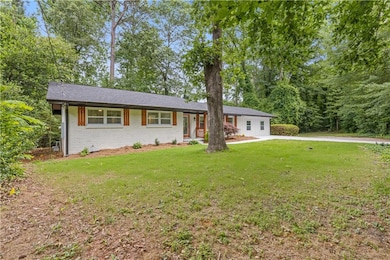 Single story home with a front lawn and brick siding