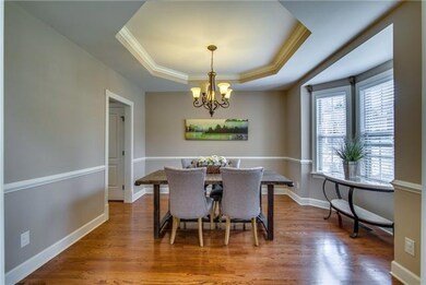 The Formal Dining Room displays a subtle elegance with an octagonal trey ceiling, crown molding, and chair rail. This room has plenty of space enhanced by the bay window.