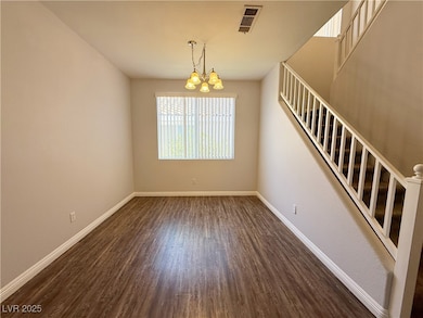 Spare room with a chandelier, stairway, and dark w