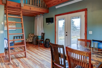 Dining room with lofted ceiling, light hardwood / wood-style flooring, and french doors