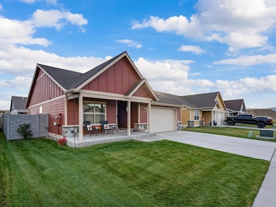 Craftsman house featuring board and batten siding, driveway, covered porch, an attached garage, and a shingled roof
