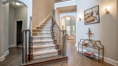 Staircase featuring arched walkways, wood finished floors, and a towering ceiling