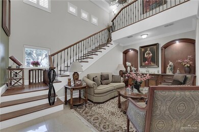 Tiled living room featuring a high ceiling, crown molding, stairs, and baseboards
