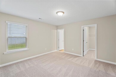 Unfurnished bedroom with multiple windows, light carpet, baseboards, and a spacious closet