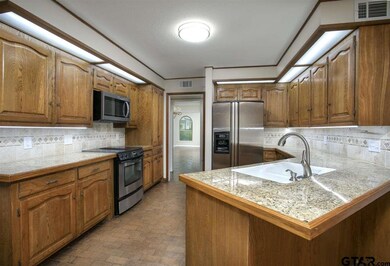 LED lighting, tumbled marble backsplash, stainless steel appliances & numerous cabinets in kitchen.