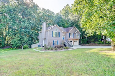 View of front of property featuring a chimney, driveway, a garage, and a front yard