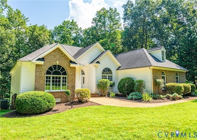View of front of property with a shingled roof, brick siding, and a front yard