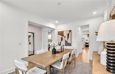 Dining area featuring light wood-style flooring, crown molding, and recessed lighting