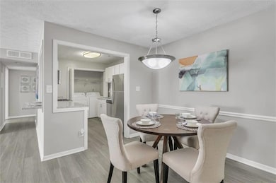 Dining room with a textured ceiling, hardwood / wo