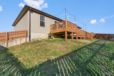 Back of property featuring a fenced backyard and a deck