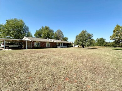View of front facade with a carport and a front ya