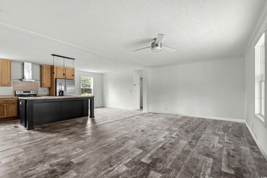 Unfurnished living room featuring baseboards, a te