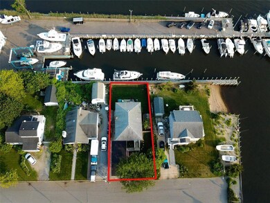 Aerial view of property and surrounding area featuring a marina, a large body of water, and property parcel outlined